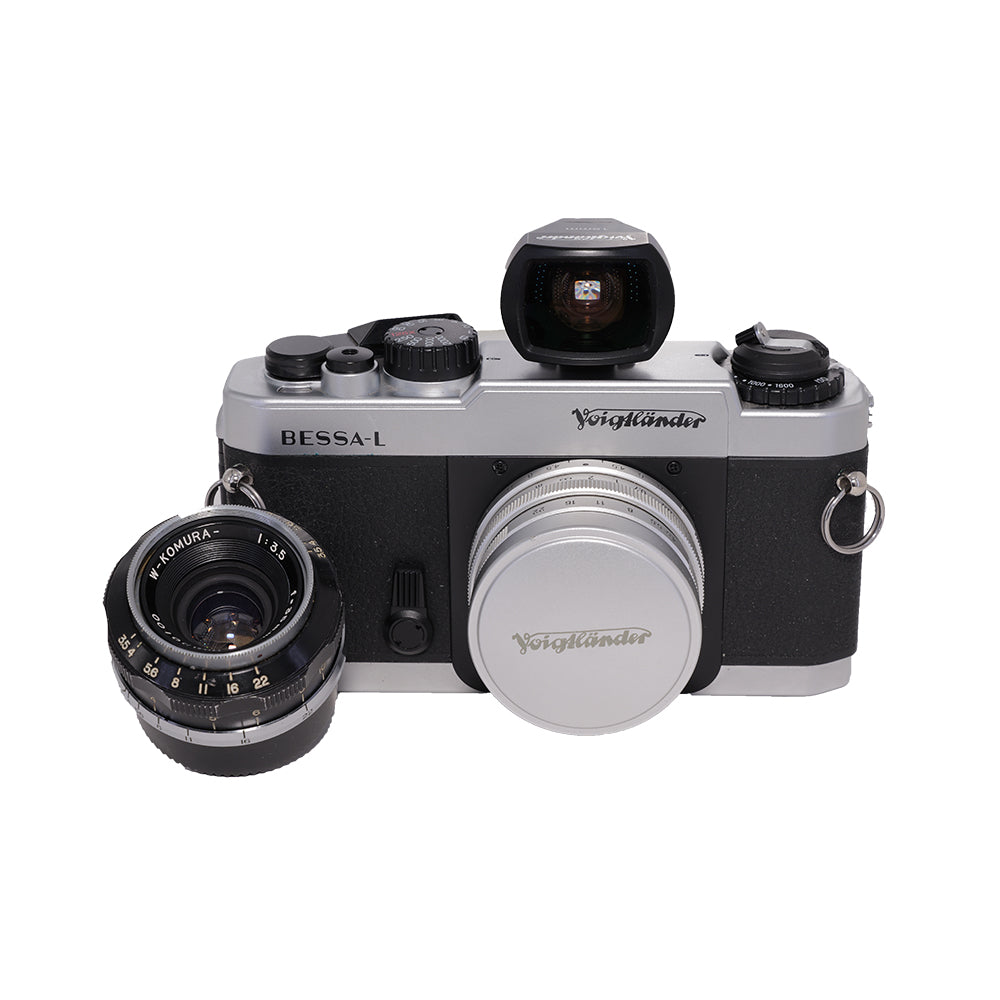 Voigtländer Bessa-L med 15 mm-søger og W-Komura 35mm f/3.5 i Leica-skruefatning ved siden af kameraet